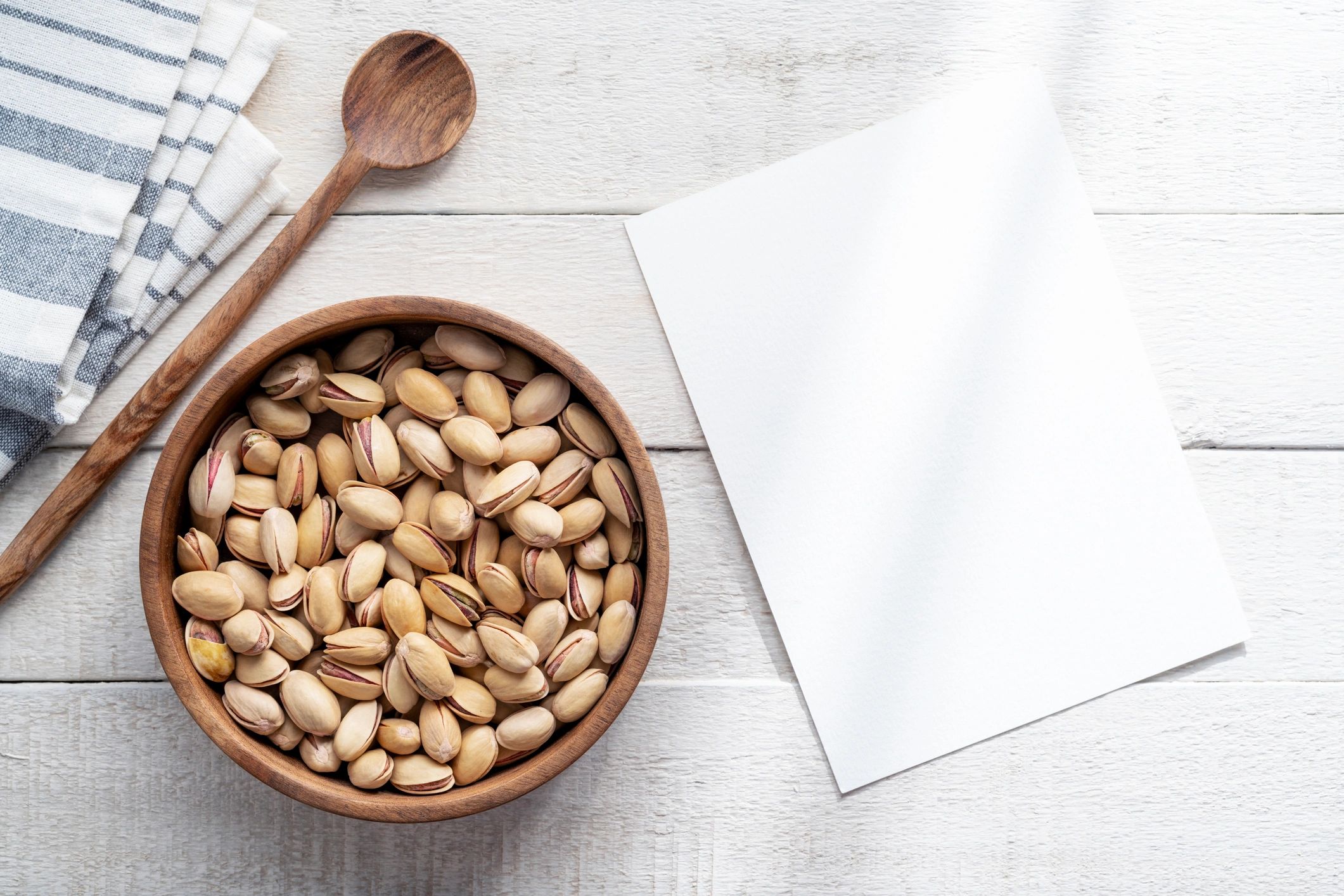 Recipe card and pistachios on a rustic wooden surface