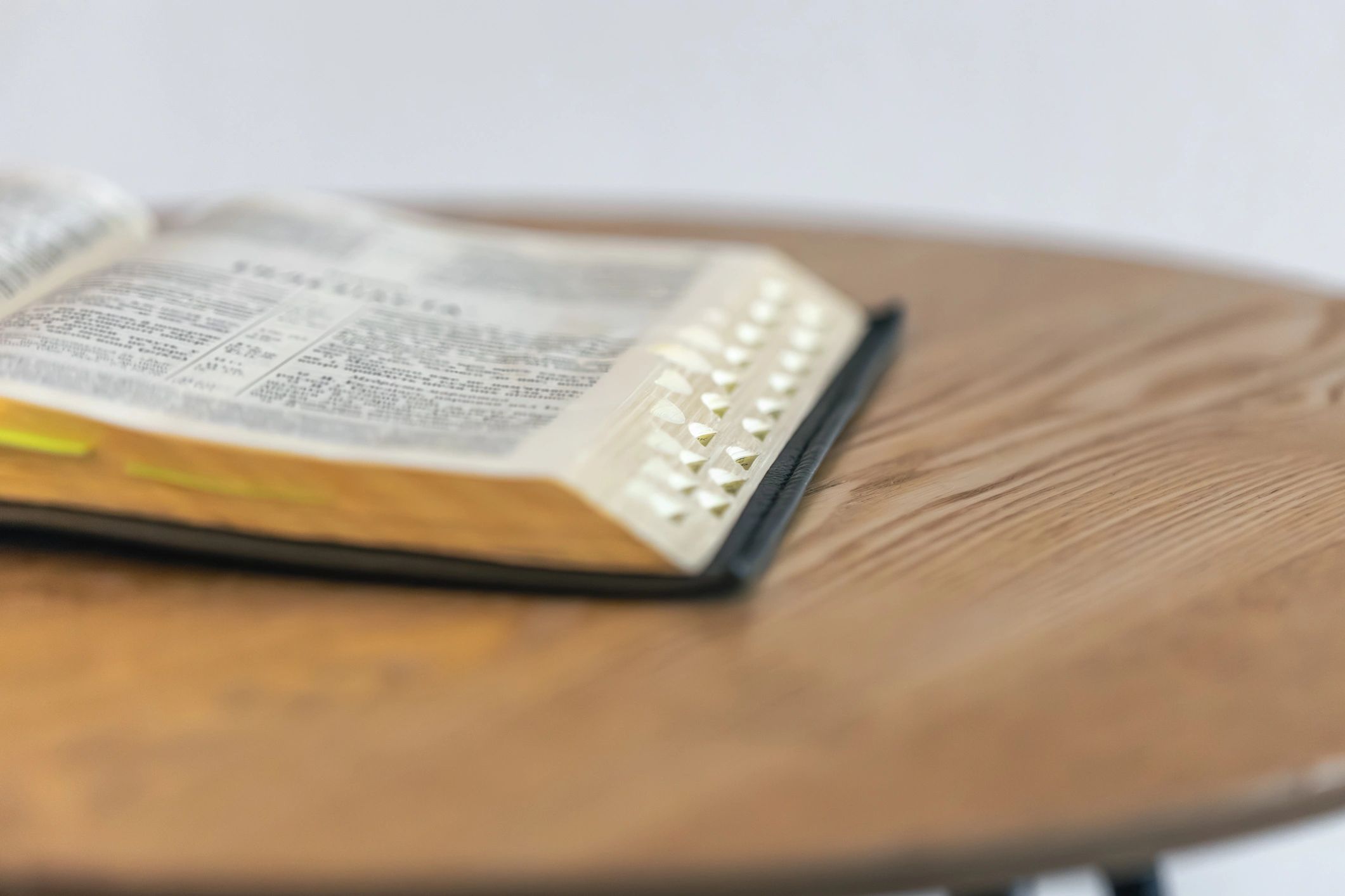 Open Bible on a rustic wooden table in soft light